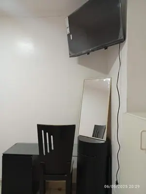 a room with a desk with a mirror and a television at Lima Colibrí habitaciones in Lima