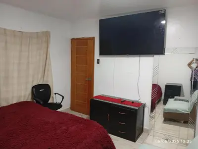 a bedroom with a bed and a flat screen tv at Colibrí12 in Lima
