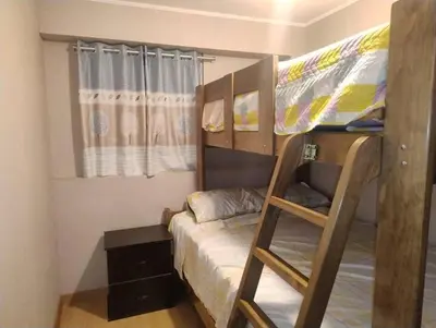 a bedroom with two bunk beds with a ladder at Depa con estacionamiento 3 dorm en Av Brasil in Lima