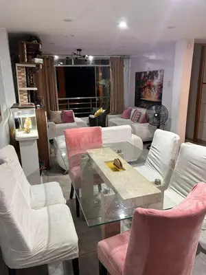a living room with white chairs and a glass table at Departamento Palmeras in Lima