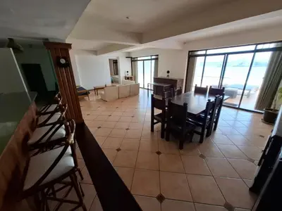 a dining room and living room with a table and chairs at Casa 4 DORM - 3 VISTAMAR, 14 a 20 pax piscina propia in San Bartolo