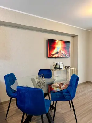 a dining room with a glass table and blue chairs at Lima Central Apartment in Lima