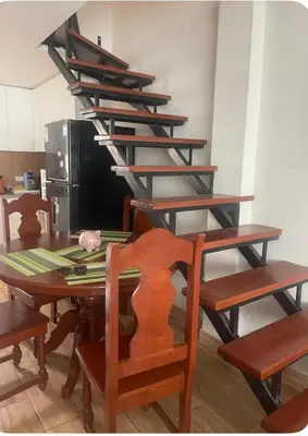 a dining room table with wooden chairs and a shelf at Quiet room in Lima
