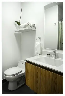 a white bathroom with a toilet and a sink at Fantastic New Apartment with Rooftop Pool and Gym in San Isidro in Lima