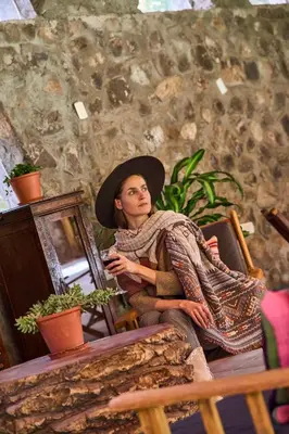 a woman wearing a hat sitting in a chair at Piedra Wasi Ecolodge Urubamba in Urubamba
