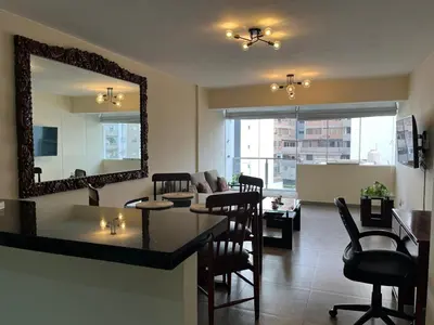 a living room with a mirror and a table and chairs at Style and location in Miraflores by AG in Lima