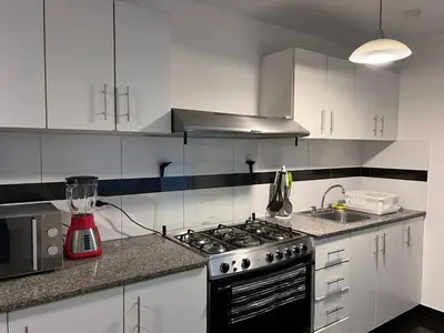 a kitchen with a stove and a blender on the counter at Villaflores Apartments in Lima