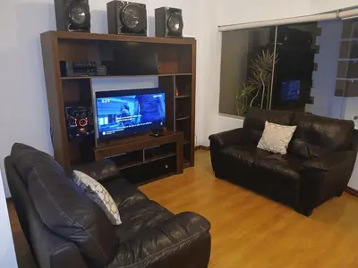 a living room with two leather couches and a flat screen tv at Miraflores ocean view in Lima