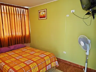 a bedroom with a bed and a fan at Hostal Geminis in Ica