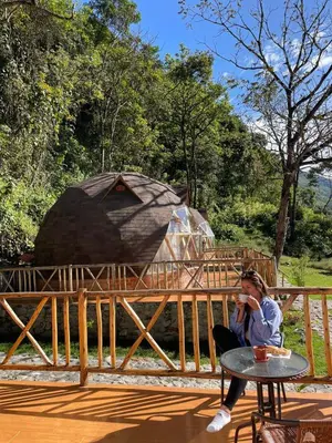 a woman sitting at a table talking on a cell phone at Salkantay Majestic Domes Eco Lodge in Sahuayacu
