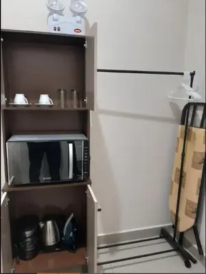 a cupboard with a microwave in a kitchen at Habitación privada cerca a la plaza Constitución en un 1er piso in Huancayo