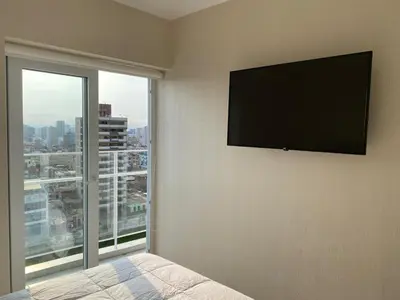 a bedroom with a flat screen television on the wall at VIP Apartment TORRE TEMPO in Lima