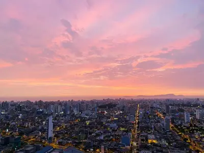 a view of a city with a sunset at VIP Apartment TORRE TEMPO in Lima