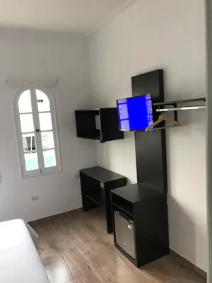 a room with black furniture and a tv on the wall at Larq'a Park Rooms in Lima