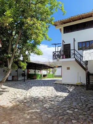 a building with a tree and a patio at Samana House Yanahuara Valle Sagrado in Urubamba