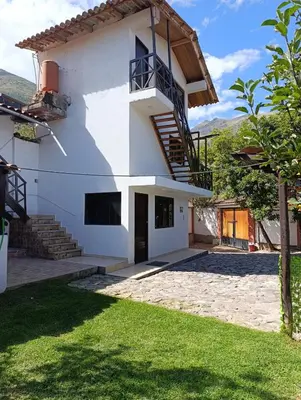 a white house with a staircase and a yard at Samana House Yanahuara Valle Sagrado in Urubamba