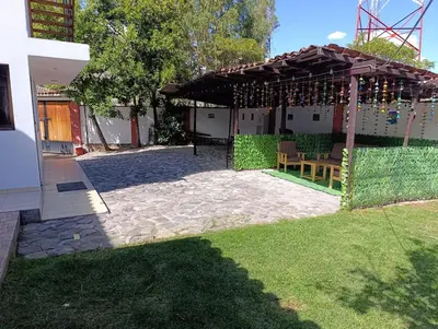 a backyard with a pergola with wine bottles at Samana House Yanahuara Valle Sagrado in Urubamba