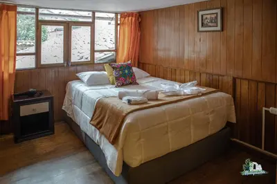 a bedroom with a bed in a room with wooden walls at HISTORIC CENTRAL Apartment in Cusco