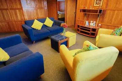 a living room with blue couches and yellow chairs at HISTORIC CENTRAL Apartment in Cusco