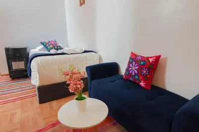 a living room with a couch and a table and a bed at CHARMING AND QUIET apart IN CUSCO in Cusco