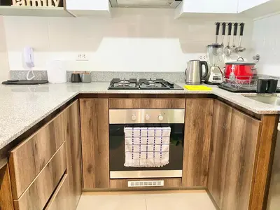 a kitchen with a stove top oven next to a counter at Departamento exclusivo con vista a la ciudad in Lima