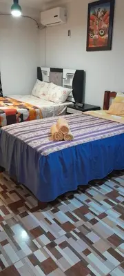 a bedroom with two beds with towels on the bed at Hostal los Faroles in Barranca