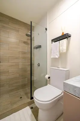 a bathroom with a toilet and a glass shower at Cozy apartment by Parque Kennedy, Miraflores in Lima