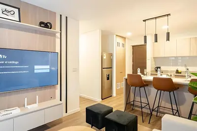 a kitchen with a tv and a kitchen with stools at Edificio Los Pinos in Lima