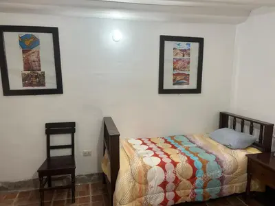 a bedroom with a bed and a table and a chair at Bed and Breakfasts - Ollantaytambo by ViaHero in Ollantaytambo