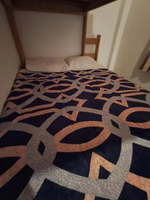 a bedroom with a bed with a black and white comforter at Bellavista Hospedaje Vista asombrosa in Oxapampa