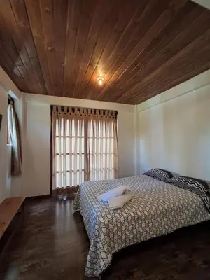 a bedroom with a bed with a wooden ceiling at Bellavista Hospedaje Vista asombrosa in Oxapampa
