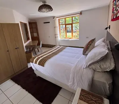 a bedroom with a large bed and a window at Urquillos Wasi - Andean Cottage in Urubamba