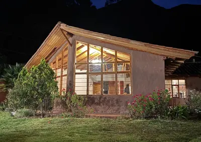 a small house with a large window in a yard at Urquillos Wasi - Andean Cottage in Urubamba