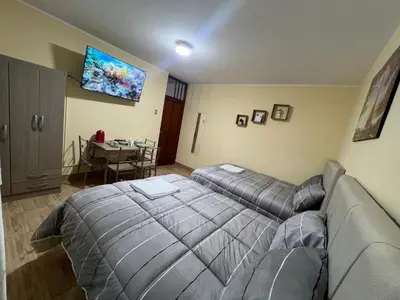 a bedroom with a bed and a couch and a table at Habitaciones privadas para alojamiento en Ica, Perú in Ica
