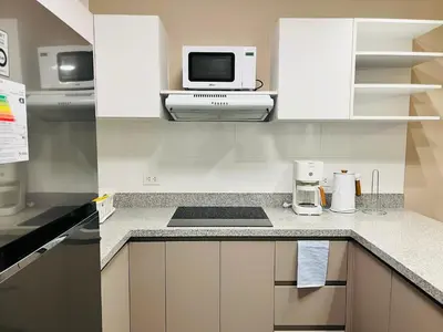 a kitchen with white cabinets and a microwave at Beautiful cozy apartment in Cusco