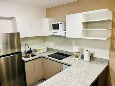 a kitchen with white cabinets and a stainless steel refrigerator at Beautiful cozy apartment in Cusco