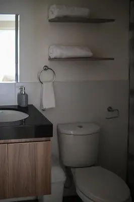 a bathroom with a white toilet and a sink at Lovely apartment in Lima