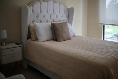 a bedroom with a large bed with a white headboard at Lovely apartment in Lima