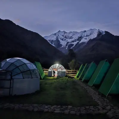 a group of domes with mountains in the background at Salkantay starcamp in Anta
