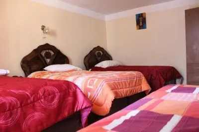 a room with two beds with red and orange blankets at Imperial Cusco INN in Cusco