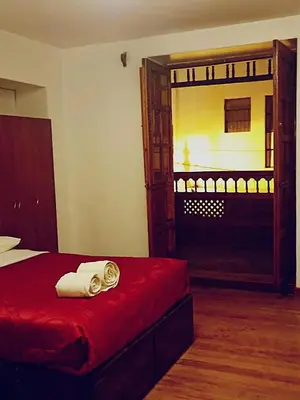 a bedroom with a red bed and a large window at Imperial Cusco INN in Cusco