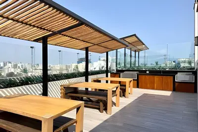 a patio with tables and benches on a roof at Edificio Olavegoya in Lima