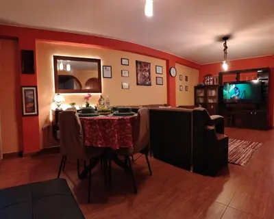 a living room with a table and a tv at Casa Hilda in Huancayo