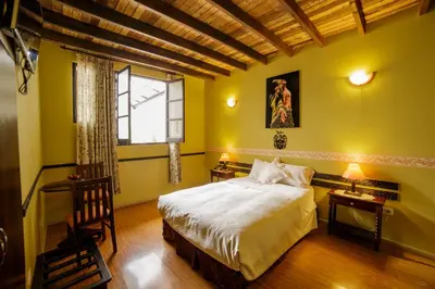 a bedroom with a large bed and a window at Yabar Hotel Plaza in Cusco