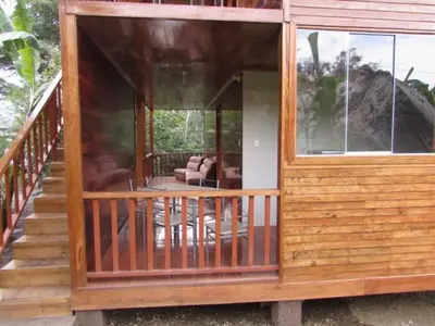 a wooden house with a porch and a living room at Ecolodge Don Felix in Quillabamba