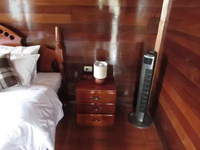a bedroom with a bed and a candle on a night stand at Ecolodge Don Felix in Quillabamba