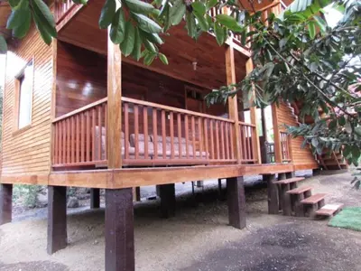 a wooden house with benches in front of it at Ecolodge Don Felix in Quillabamba