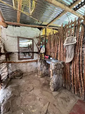 a room with a stone wall with a table and a window at Jungle Lodge Quillabamba All included