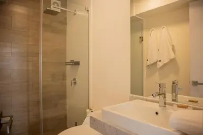 a bathroom with a white sink and a shower at Sight Oceanview in Barranco Malecon by Wynwood House in Lima