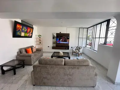 a living room with two couches and a flat screen tv at Casa de Stephano in Lima